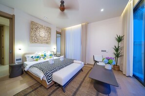 Une chambre d’hôtel moderne avec un grand lit, des tables de chevet, un bureau et une grande fenêtre avec des rideaux.