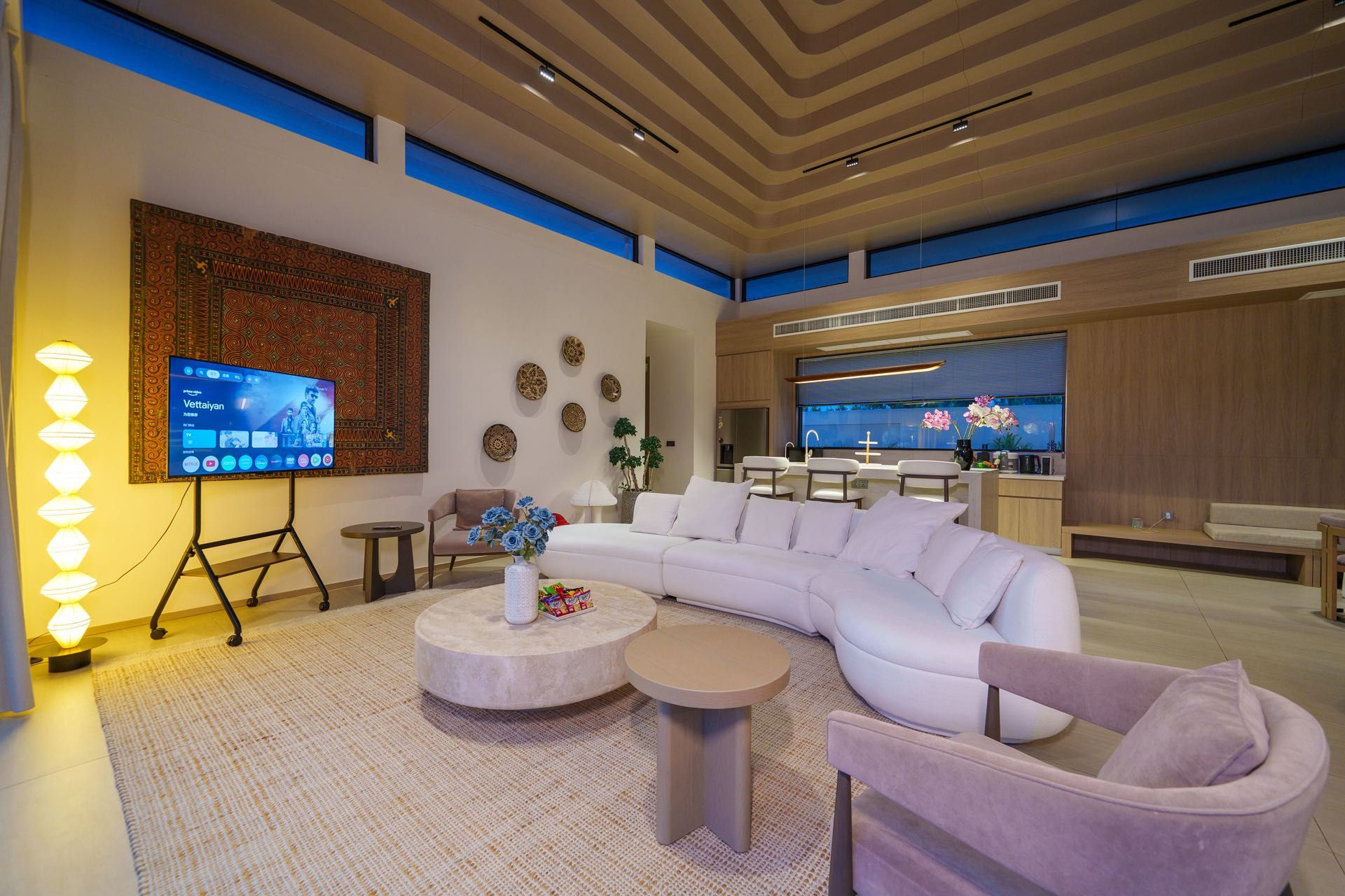 A modern living room with a large L-shaped sofa, a coffee table, and a television.