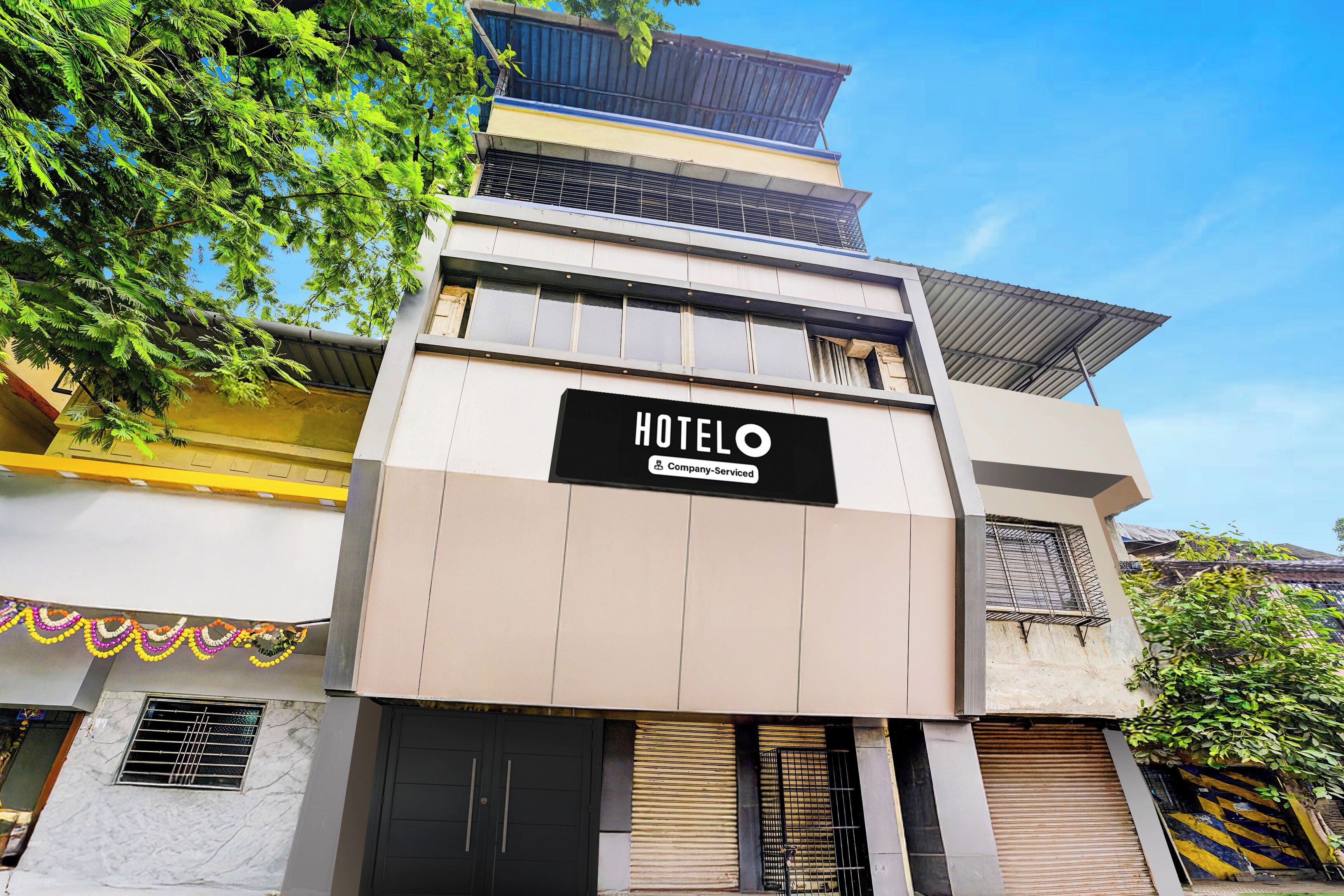 A hotel building with a sign reading 'HOTELO Company Serviced'.