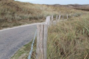 A rural road with a wooden fence and grassy terrain. - Beach House Ogentroost (Julianadorp)