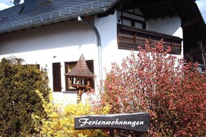 A traditional building with a sign reading 'Ferienwohnungen' indicating it is a guesthouse or holiday home. - Panoramic holiday apartment with lake view (Schalkenmehren)