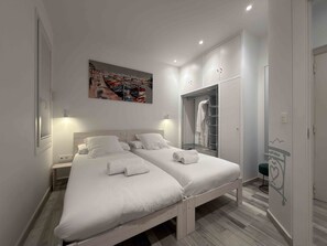 Une chambre avec deux lits, une armoire, un miroir et un tableau au mur.