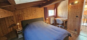 A bedroom with a bed, a desk, and a chair. - Le Montagnard (8 people) View of Mont Blanc & covered parking (Saint-Gervais-les-Bains)