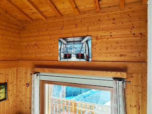 Interior de fusta amb una finestra i vista a un paisatge nevat.
