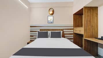 Un dormitorio moderno con cama, mesitas de noche, cabecera de madera y una lámpara fijada a la pared.