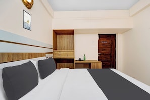 A hotel room with a bed, a desk, a wardrobe, and a door. - Super Hotel O Vilankurichi (Coimbatore)