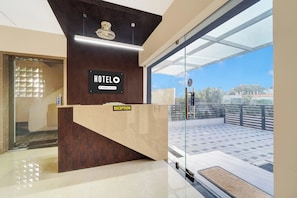 A hotel reception desk with a sign indicating it's company-serviced. - Super Hotel O Vilankurichi (Coimbatore)