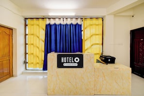 A hotel reception desk with a sign indicating it is company-serviced.