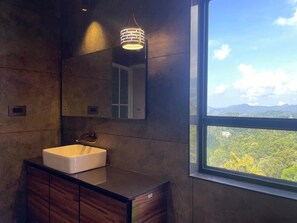 A bathroom with a large window, a sink, and a mirror. - Ajsan Munnar Resorts (Devikolam)