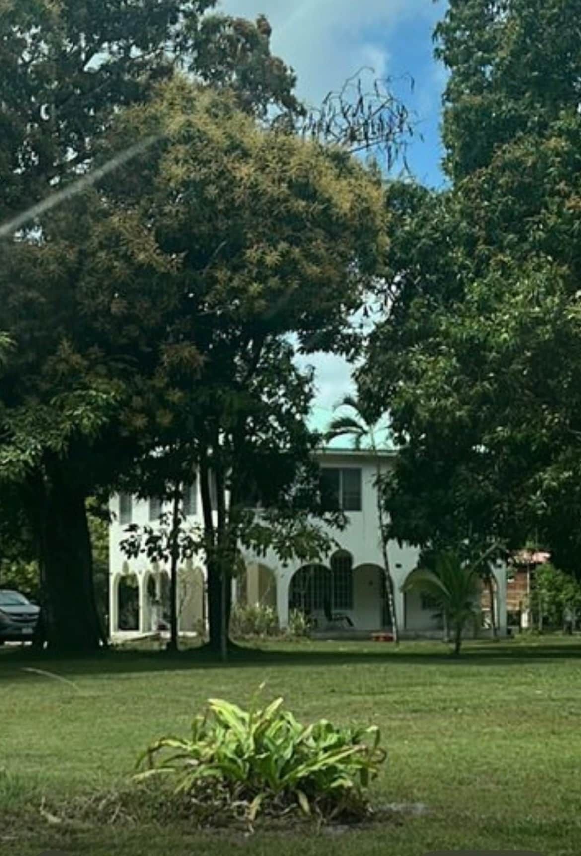 A building with arched windows and a lawn in the foreground.