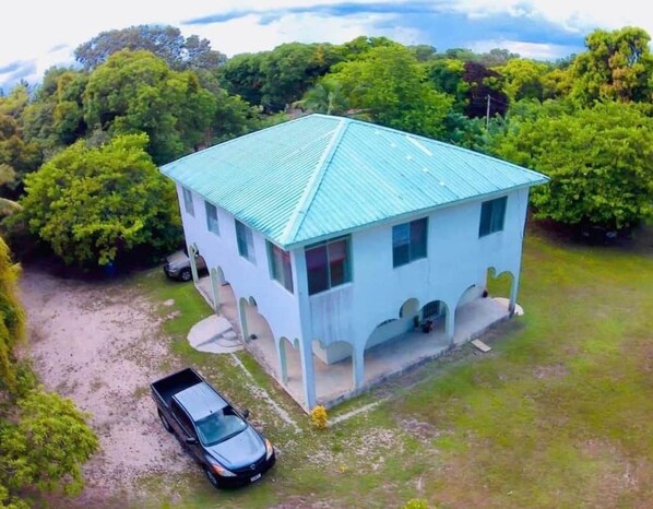 A single-story building with a sloped roof, surrounded by lush greenery.