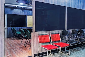 Une salle d’attente avec des chaises et une table, un plancher en bois et une fenêtre.