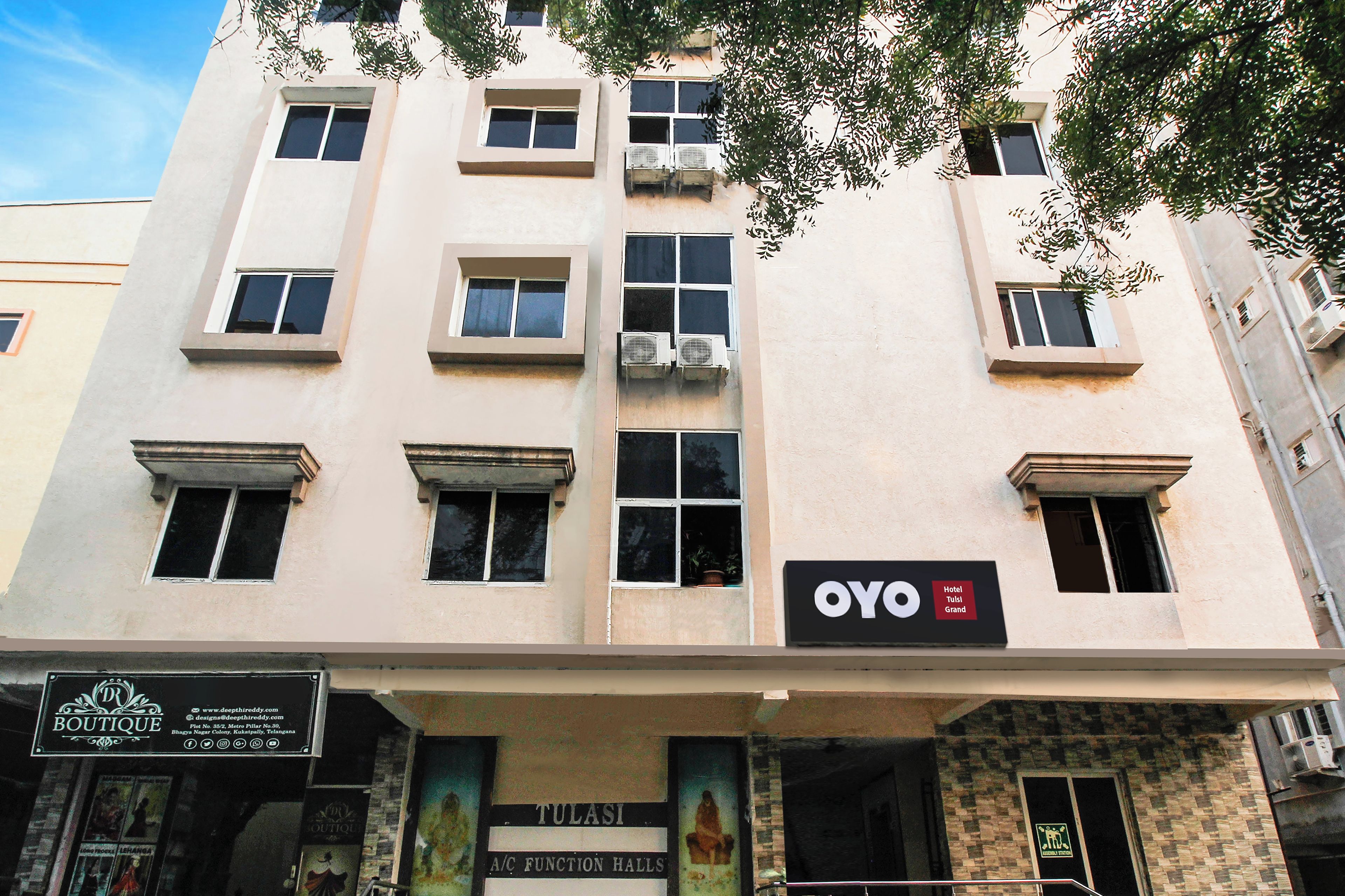 A multi-story building with a sign for 'OYO Hotel Tulsi Grand' on the facade.
