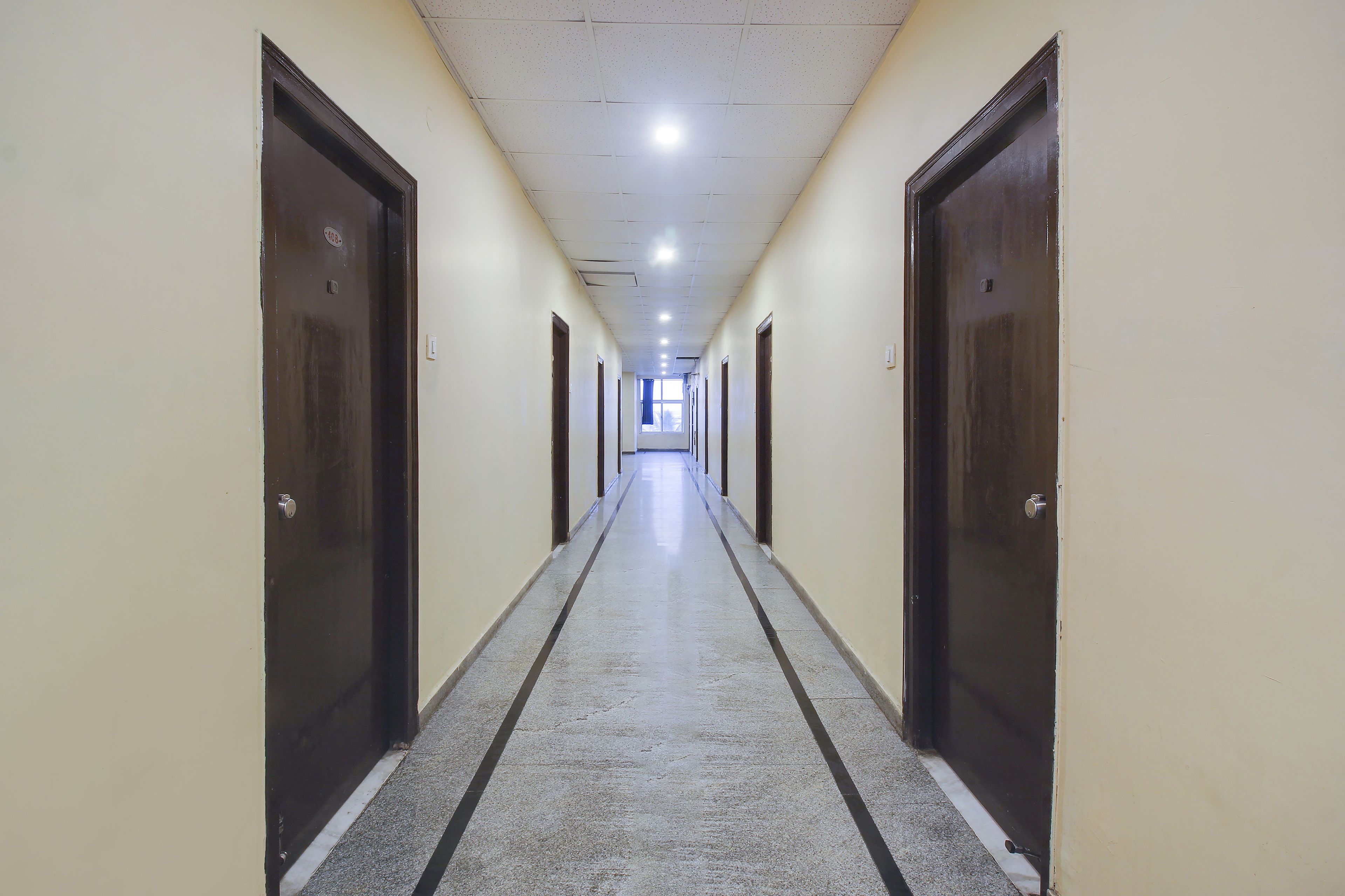 A long, narrow hallway with doors on both sides, leading to individual rooms.