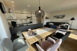 A modern living space with a dining area, kitchen, and seating area. - Holiday apartment with 1 bedroom (Zingst)