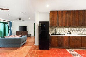 A compact living space with a kitchenette, a sofa, and a television. - HÙA 03BR 301 (Đà Nẵng)