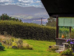 A house with a view of rolling hills and a distant mountain range.