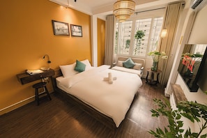 A hotel room with a large bed, bedside tables, a desk, and a window with curtains. - OH Trendy homes Hoan Kiem 3 Bedrooms - Full house 150m2 (Cua Nam)