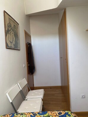 A narrow hallway with a bed on the left and a door at the end. - New Listing (Bronchales)