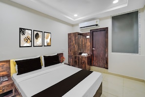 Una habitación de hotel con cama, armario y aire acondicionado instalado en la pared.