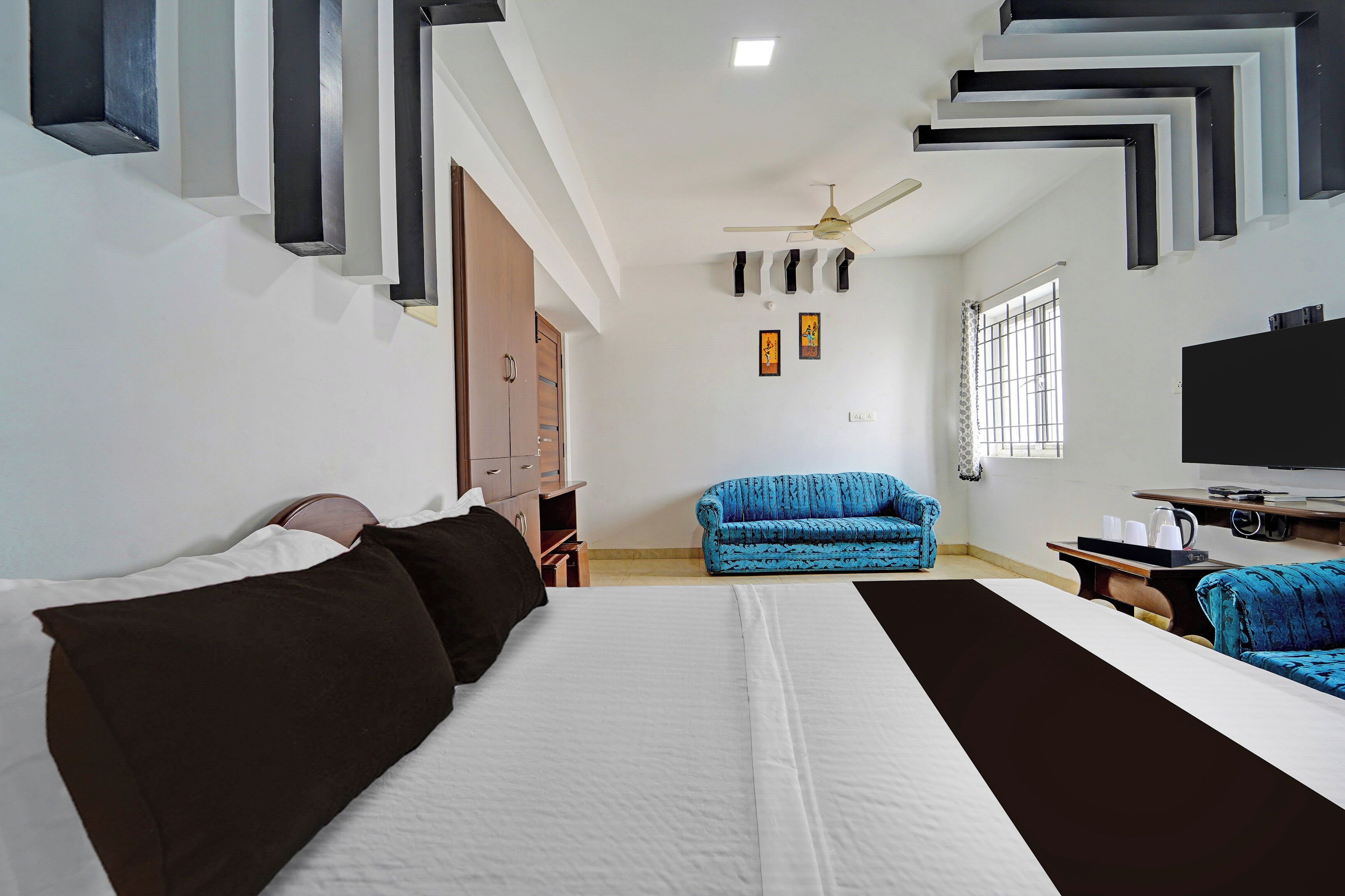 A hotel room with a bed, a sofa, a TV, and a desk.