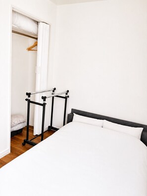 A bedroom with a bed, a wardrobe, and a mirror. - New Listing (小樽市)