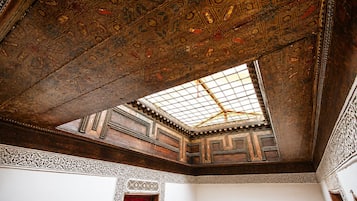 Un techo ornamentado con intrincados diseños geométricos y un tragaluz.