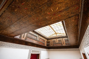 An ornate ceiling with intricate geometric patterns and a skylight. - House Ismaël Luxrious Fez (Fez)