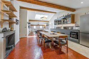A modern kitchen with a dining area, featuring a large island, built-in appliances, and a skylight. - New Listing (Avignon)