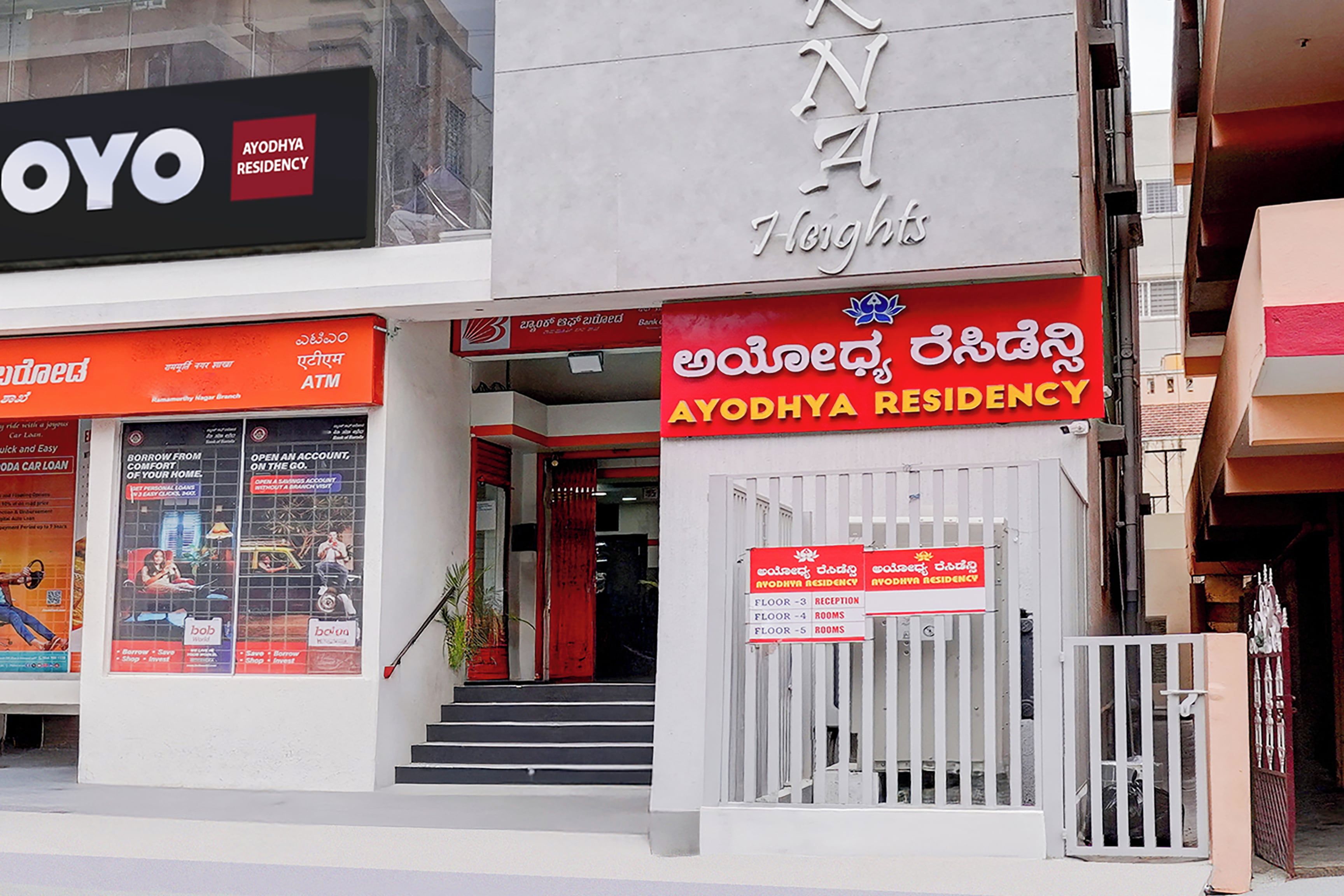 A building with a sign for 'AYODHYA RESIDENCY' and a visible ATM on the ground floor.