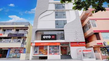 En byggnad med flera våningar och en tydlig skylt med texten ”OYO”, vilket indikerar att det är ett hotell eller ett annat boende.
