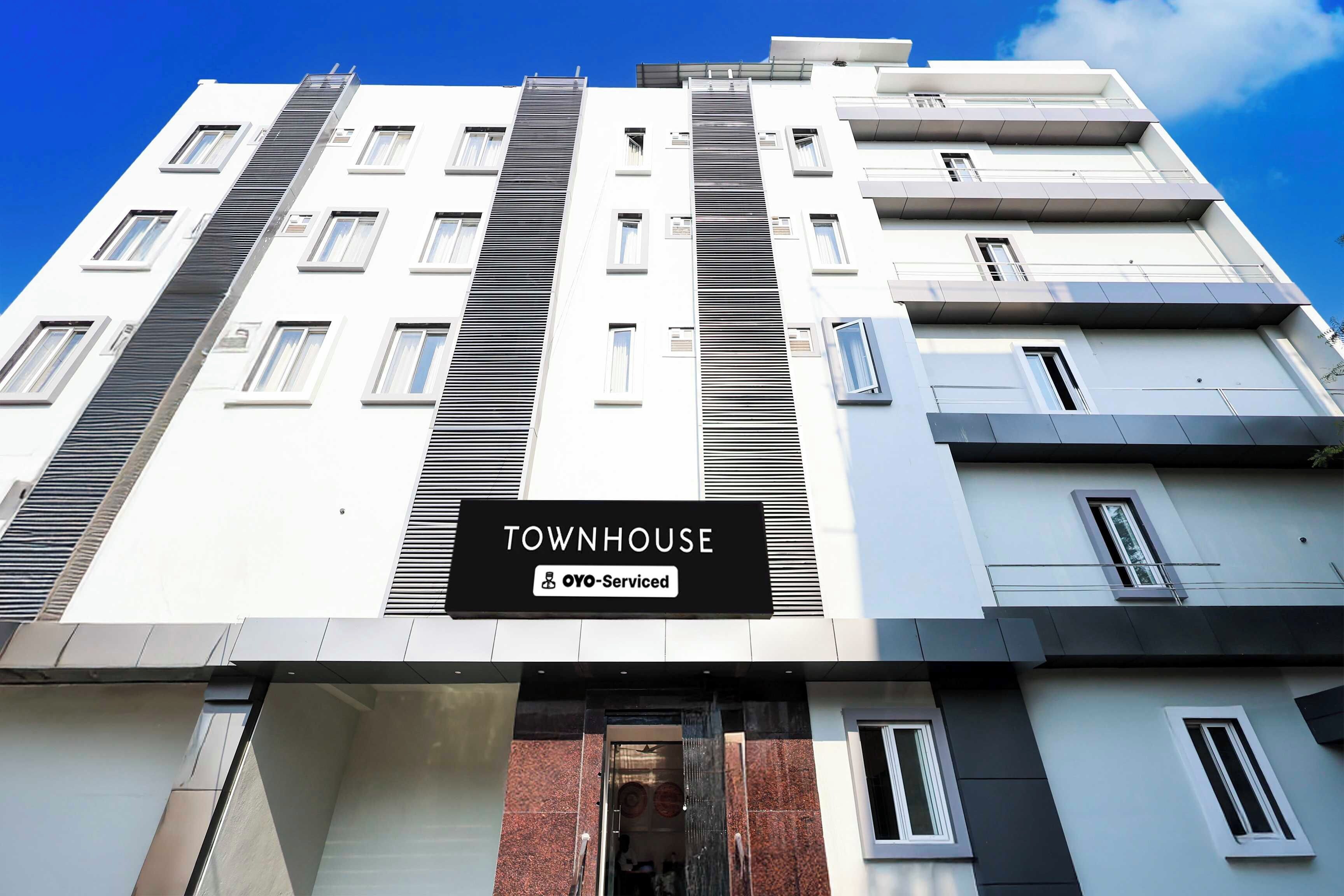 A multi-story building with a sign indicating it is serviced by OYO.