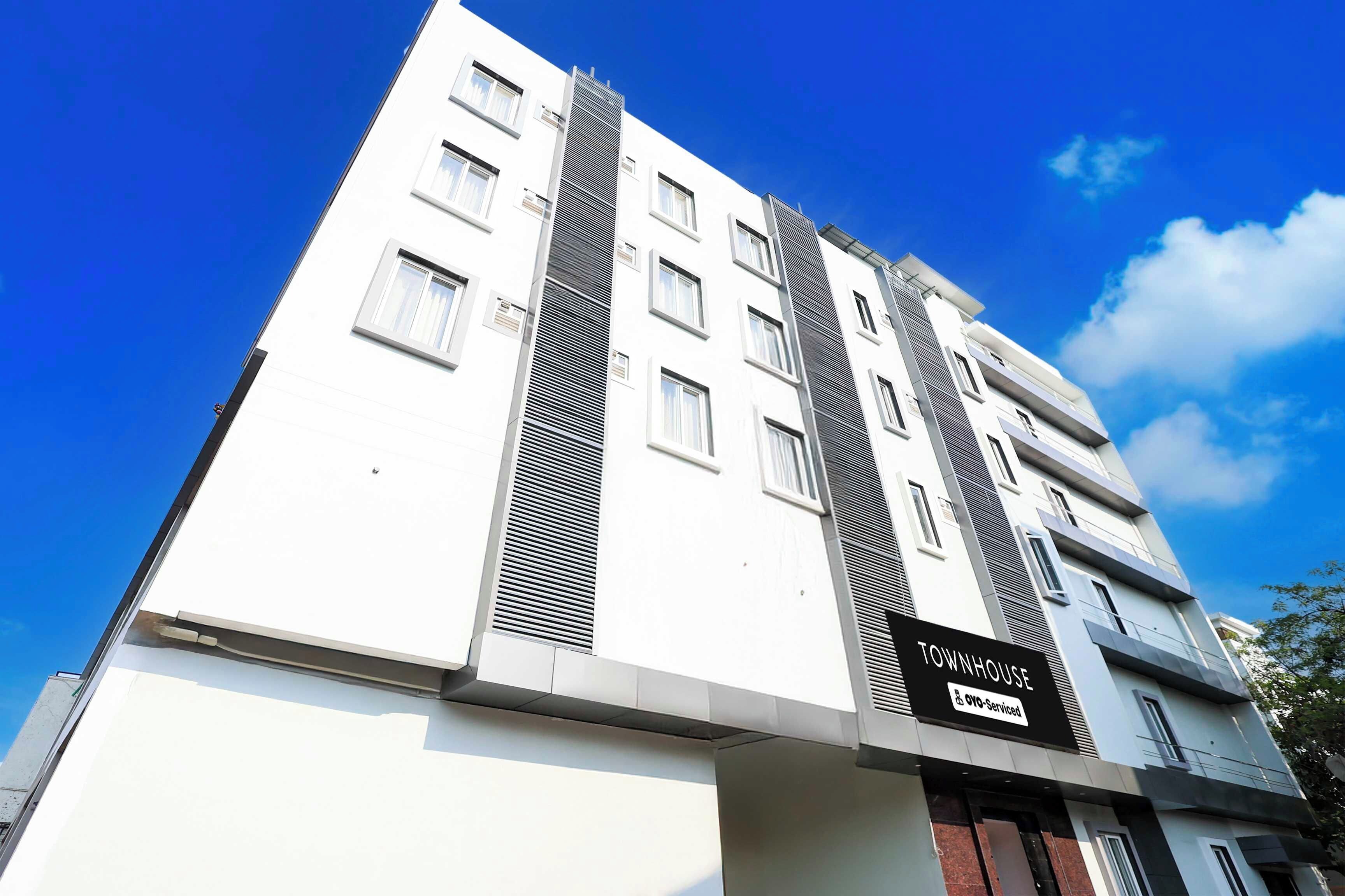 A multi-story building with a sign indicating it is a serviced townhouse.
