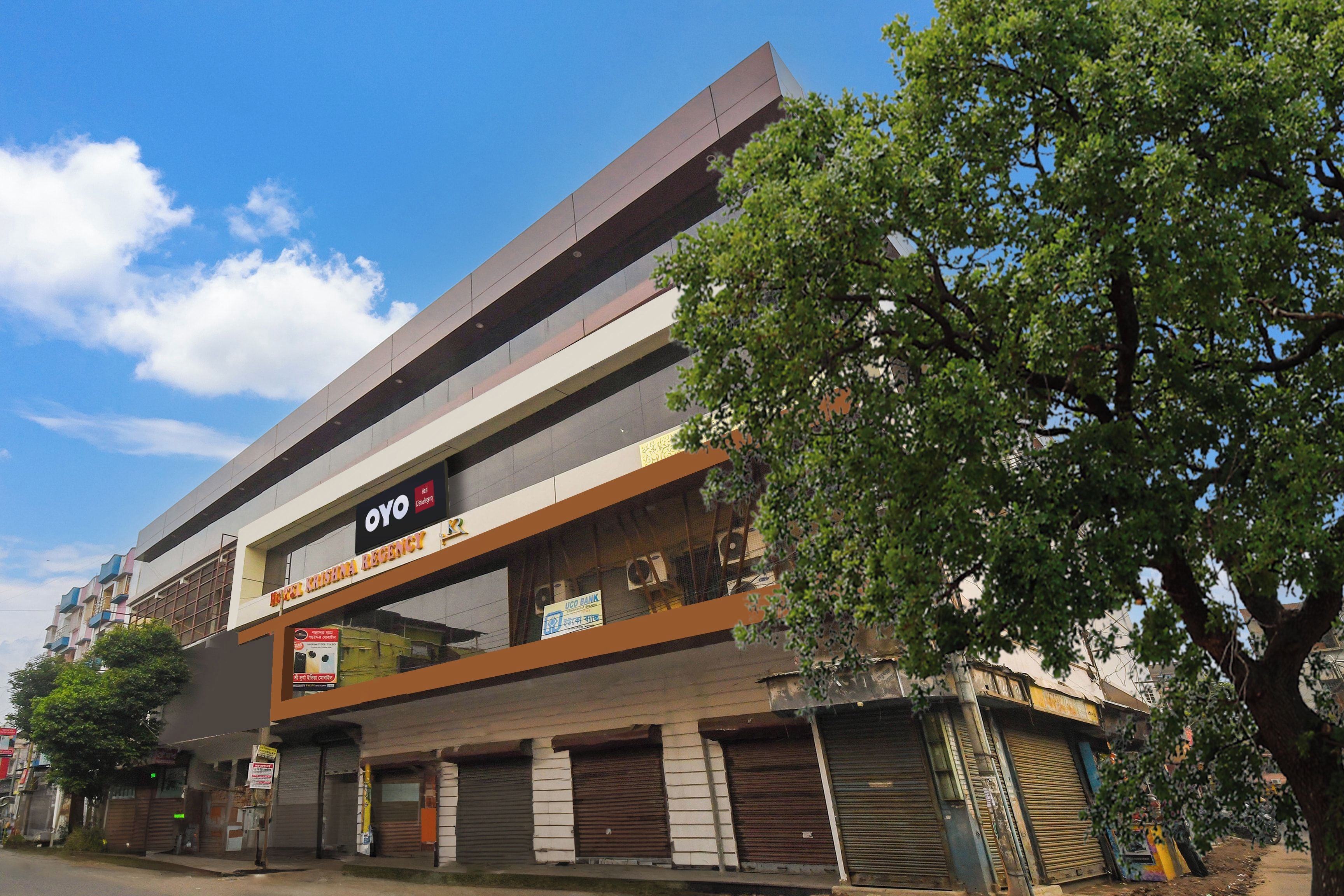 Un edificio de varios pisos con un letrero llamativo del hotel OYO.