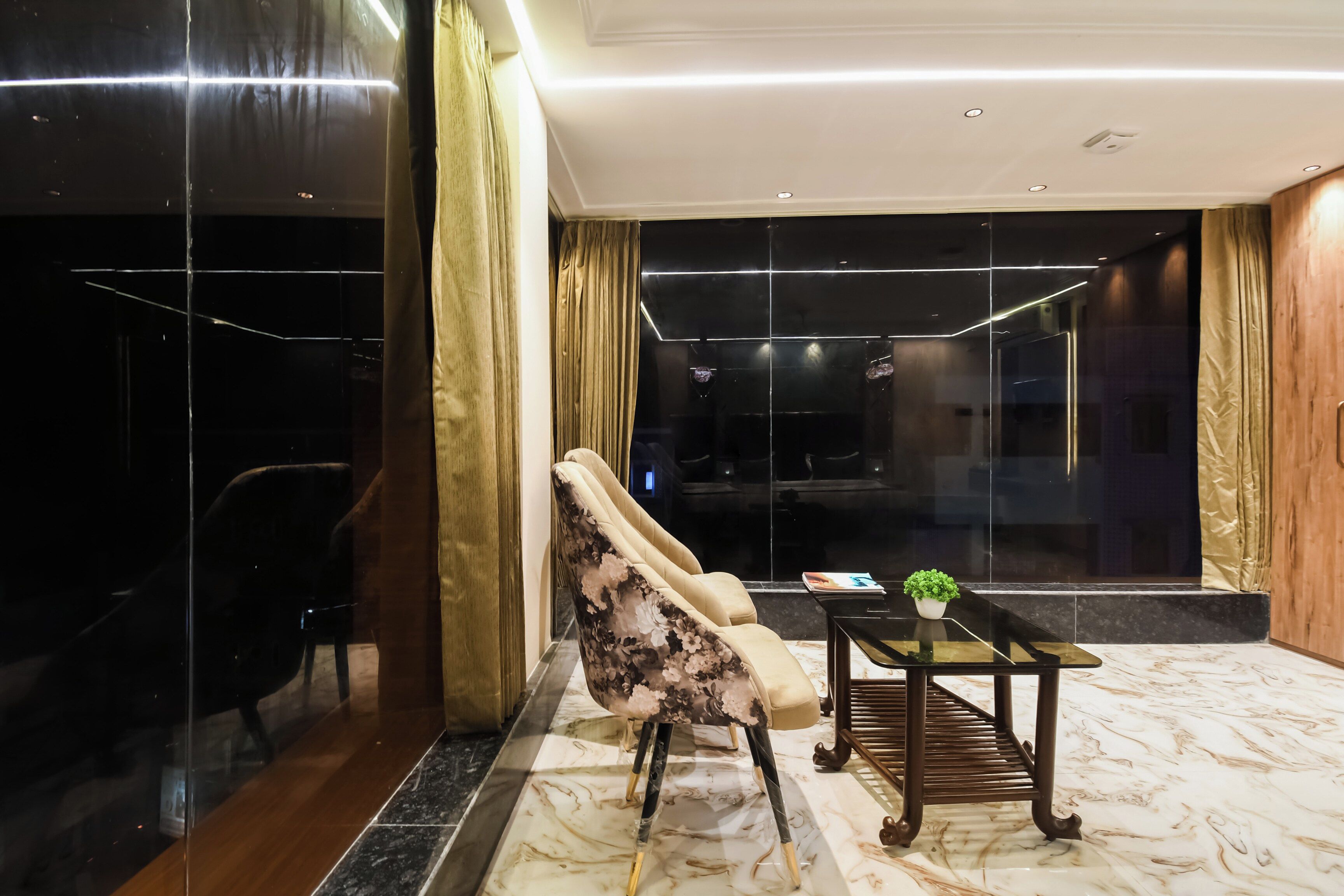 Un hall d’hôtel moderne avec un sol en marbre, un canapé, une table basse et une vue sur l’intérieur.