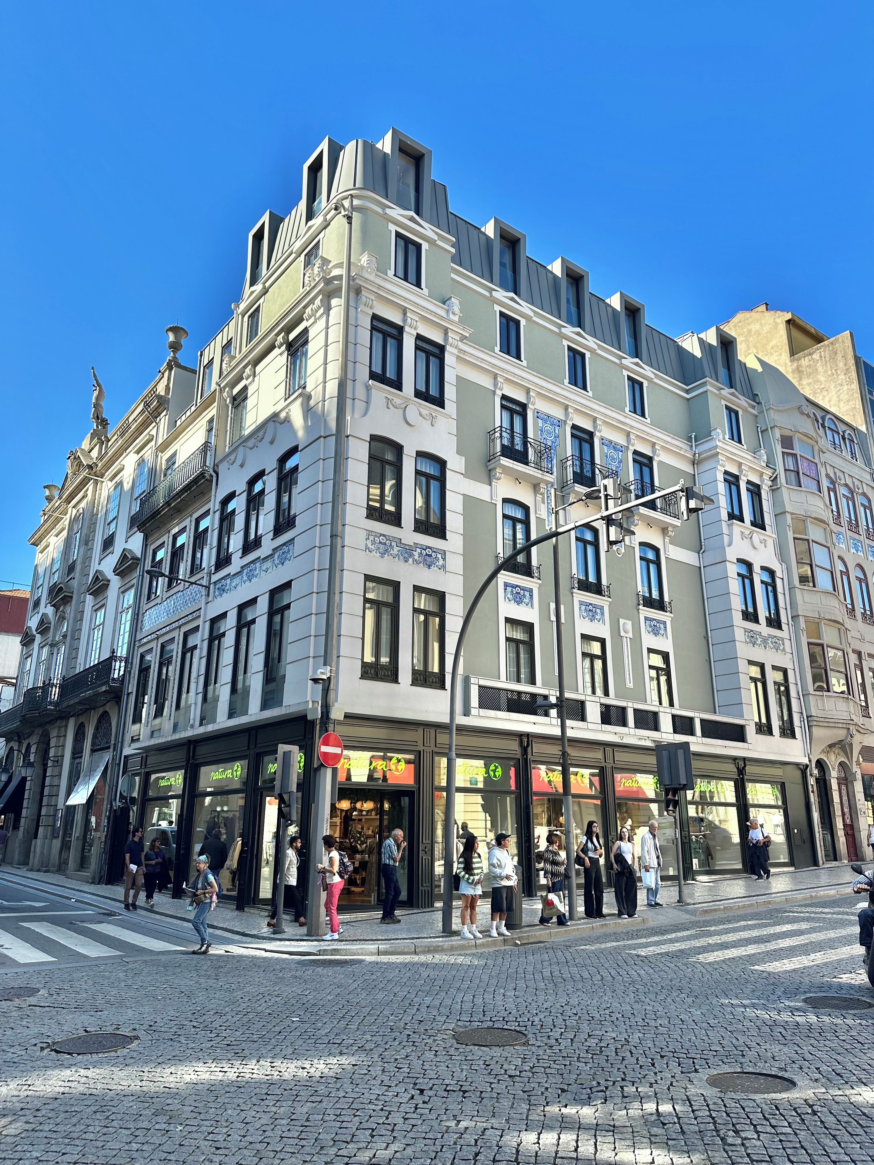 Un edificio de varios pisos con una tienda en la planta baja y apartamentos en los pisos superiores.