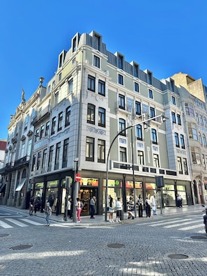 Un immeuble à plusieurs étages, avec un commerce au rez-de-chaussée et des logements aux étages supérieurs.