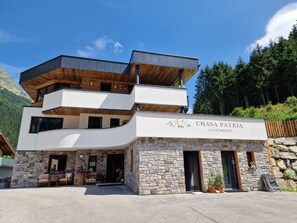 A modern multi-story building with a stone facade, labeled 'Chasa Patria Apartments.' - Chasa Patria Apartments (Ischgl)