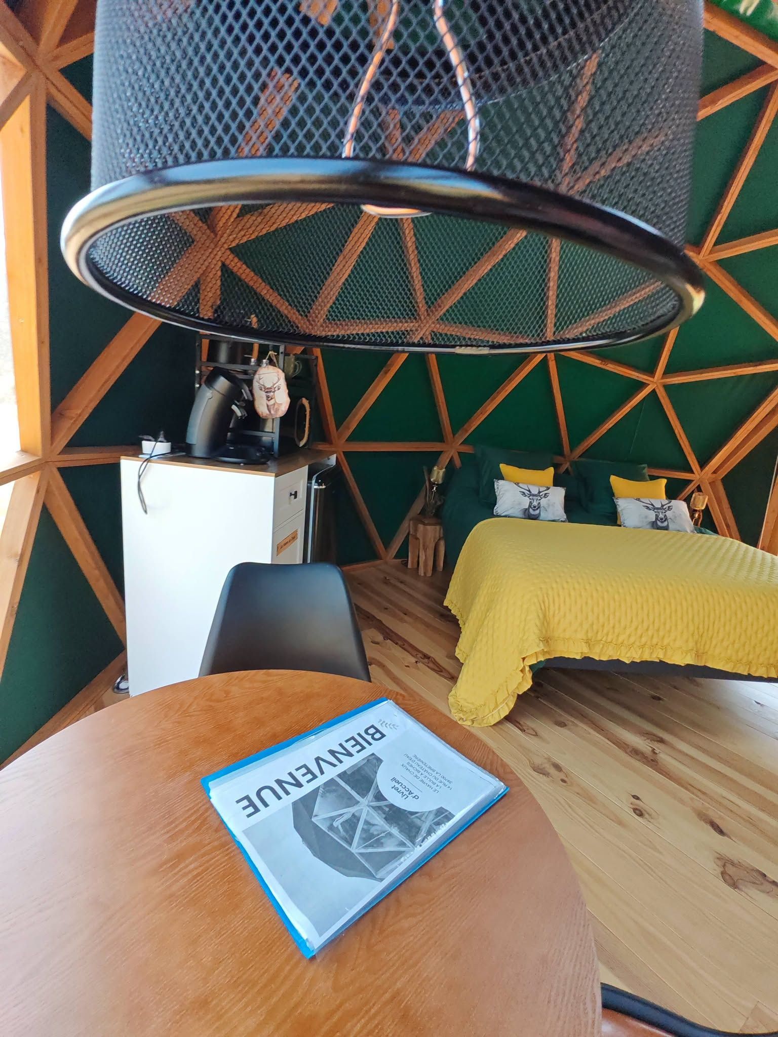 Une pièce comprenant un lit, un bureau, une chaise et une table sur laquelle se trouve un livre.