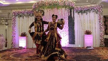 A stage with floral decorations and a patterned carpet.