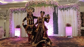 A stage with floral decorations and a patterned carpet.