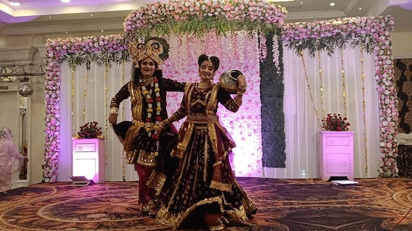 A stage with floral decorations and a patterned carpet.