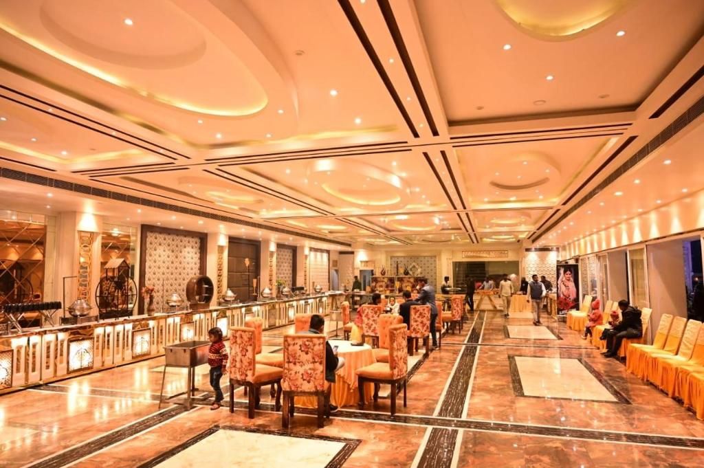 A spacious hotel lobby with a long reception desk, multiple seating areas, and a marble floor.