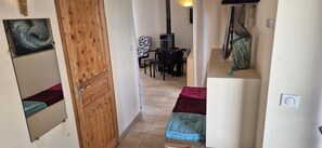 Ein Korridor mit einer Holztür, ein Essbereich mit Tisch und Stühlen sowie ein Kamin.