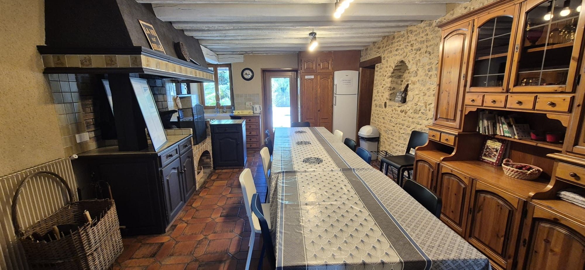Eine Küche mit einer langen Arbeitsplatte, Holzschränken und einer Steinwand.