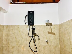 A bathroom with a handheld shower unit mounted on a tiled wall, a control panel, and a showerhead.