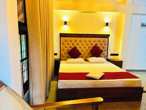 Una habitación de hotel con una cama grande, cabecera de madera y dos lámparas de noche.