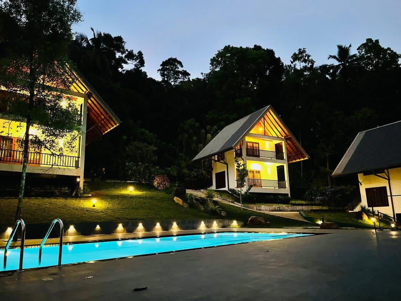 A pool area with a house in the background.