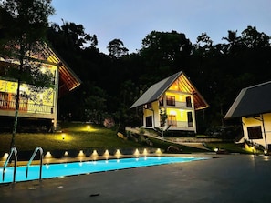 Un área de piscina con una casa al fondo.