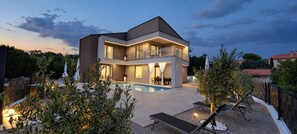 A modern two-story house with a swimming pool, outdoor seating, and a well-maintained garden. - Villa La Vie with heated pool (Garica)